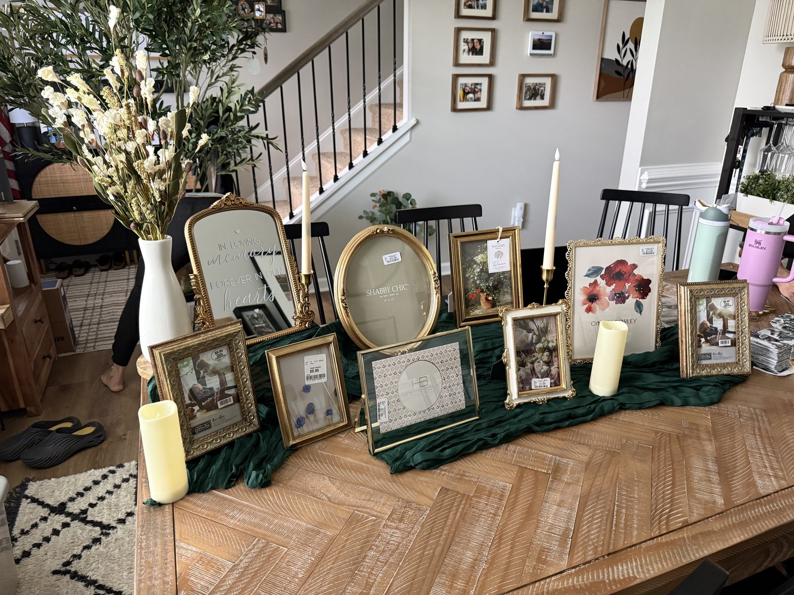 Memory table setup — mirror, frames, candles, baby's breath
